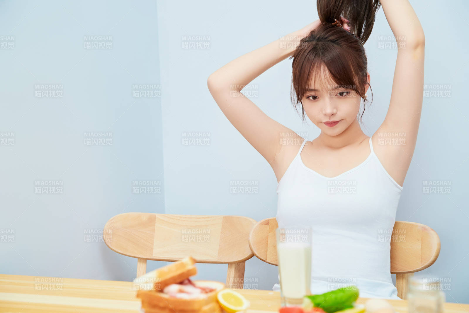 美丽的少女在餐桌前吃早餐