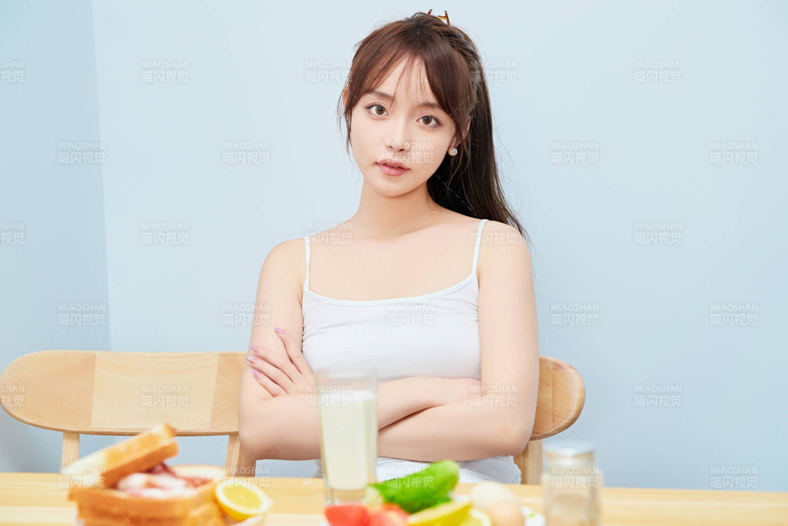 美丽的少女在餐桌前吃早餐