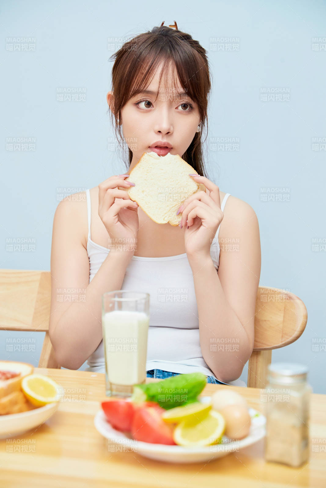 美丽的少女在餐桌前吃早餐