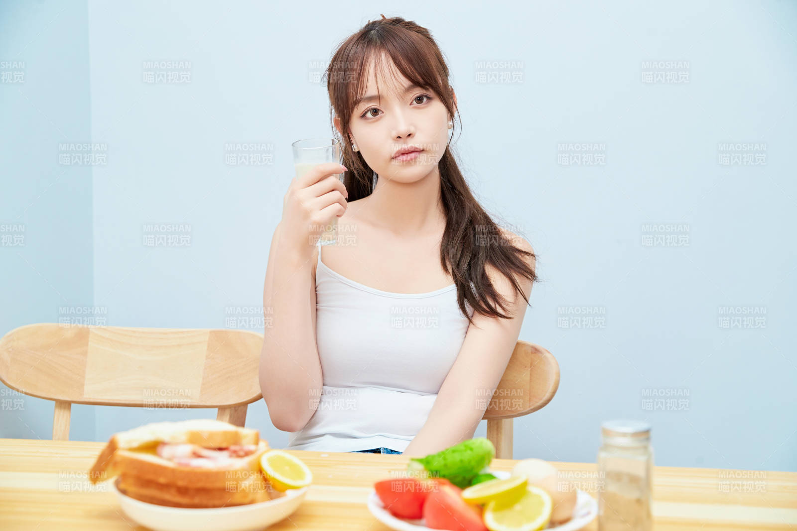 美丽的少女在餐桌前吃早餐