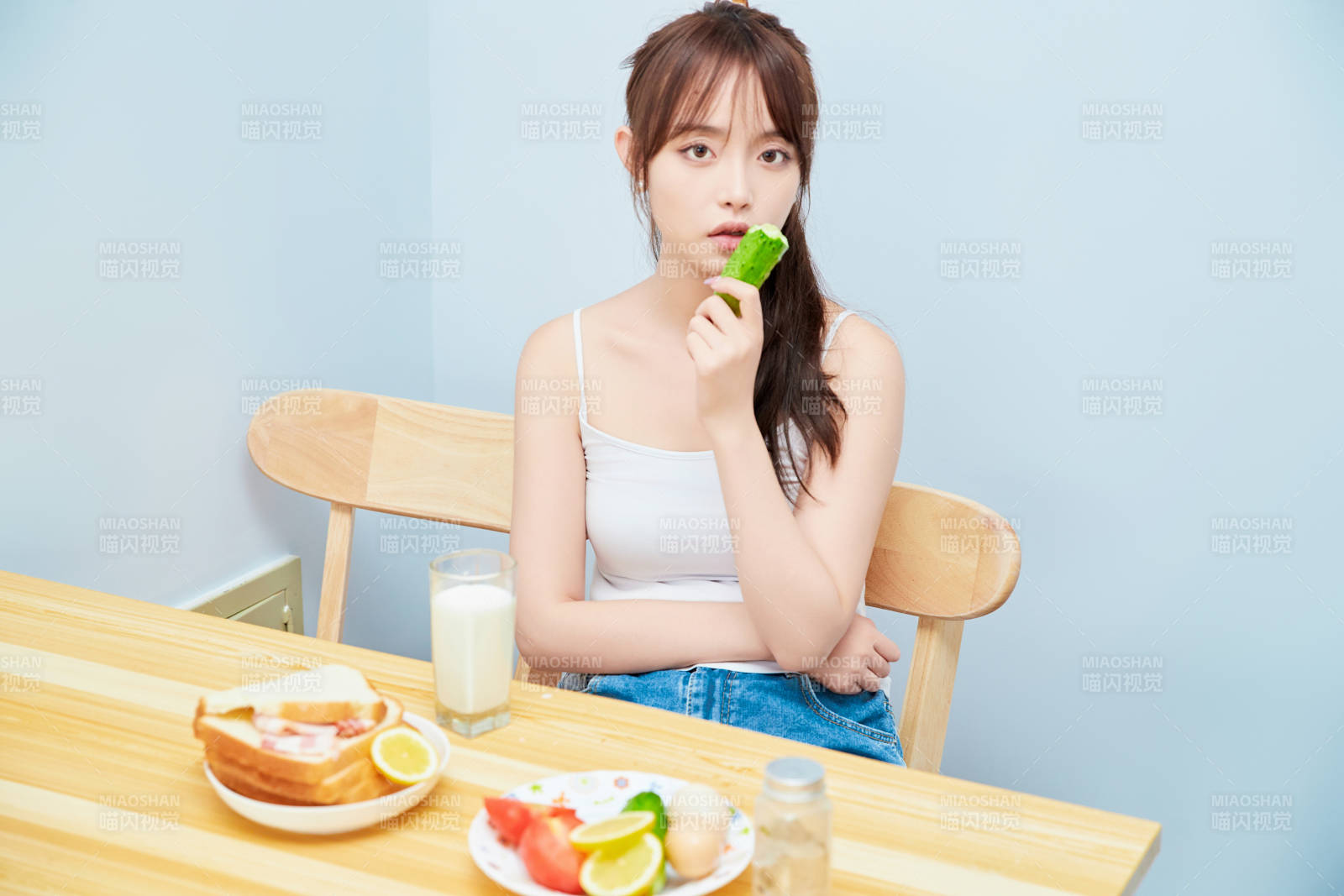 美丽的少女在餐桌前吃早餐