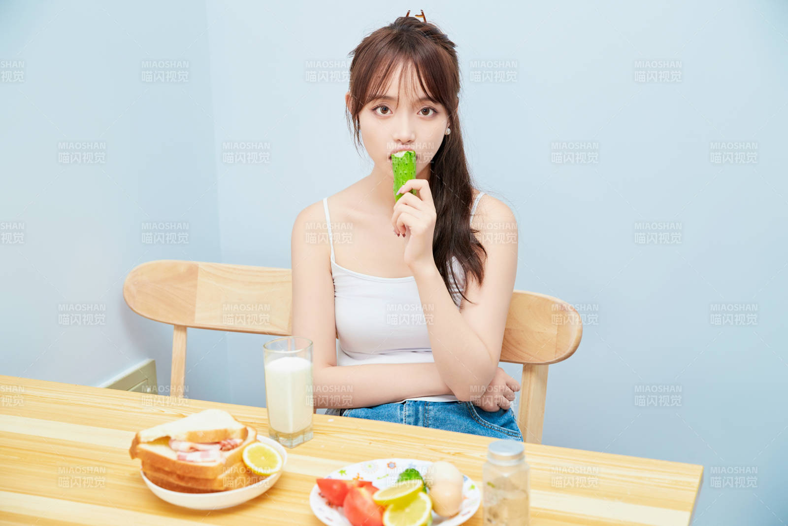 美丽的少女在餐桌前吃早餐