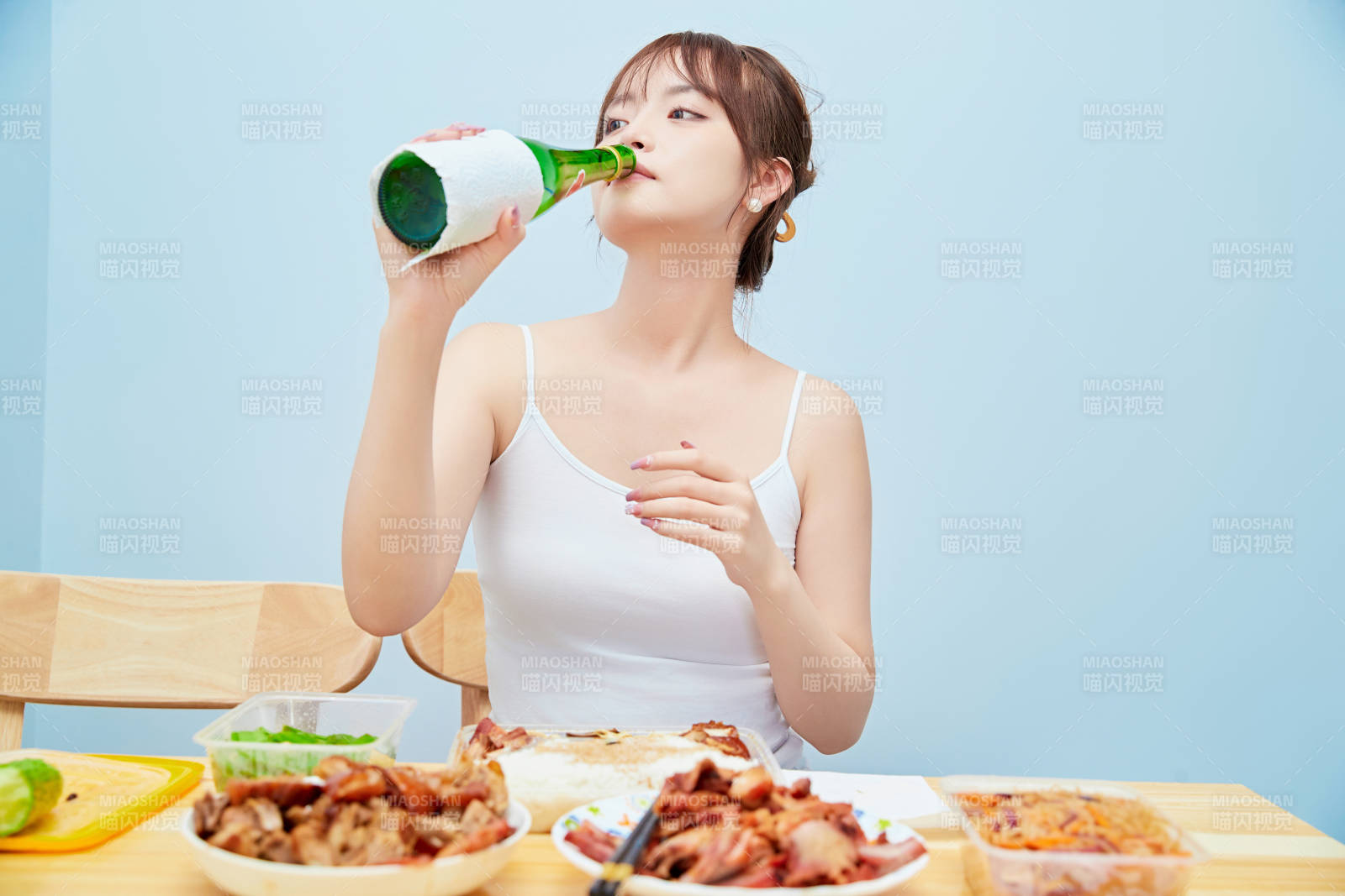 在餐桌前吃午餐喝白酒的亚洲少女