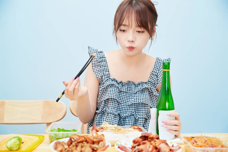在餐桌前吃午餐喝白酒的亚洲少女