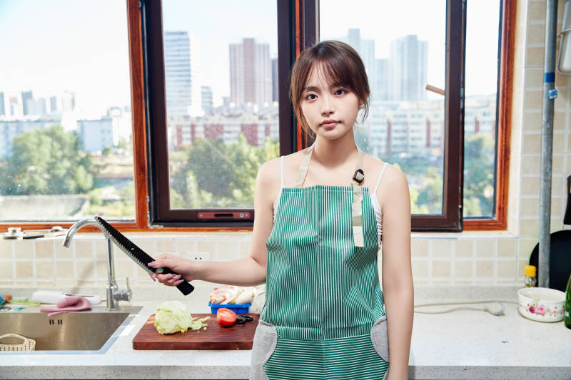 在厨房下厨做饭的年轻亚洲女性