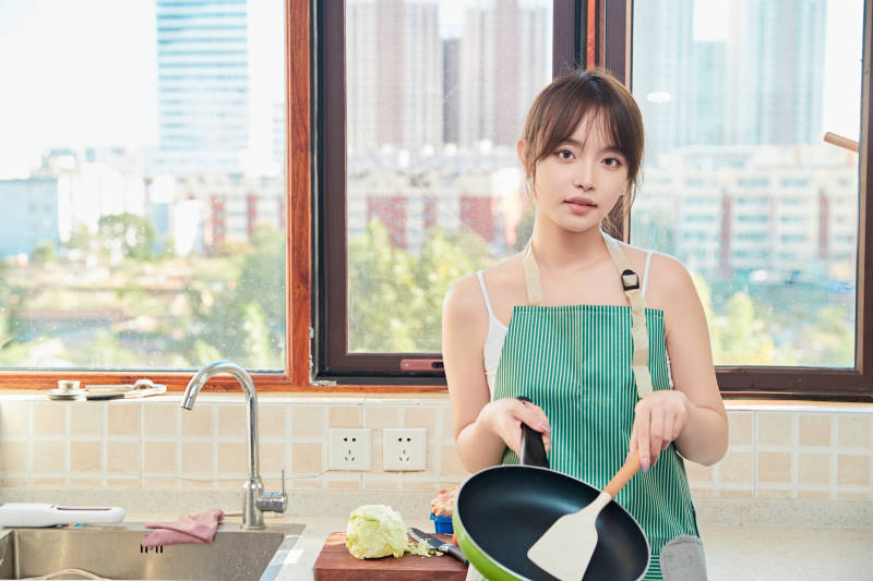 在厨房下厨做饭的年轻亚洲女性