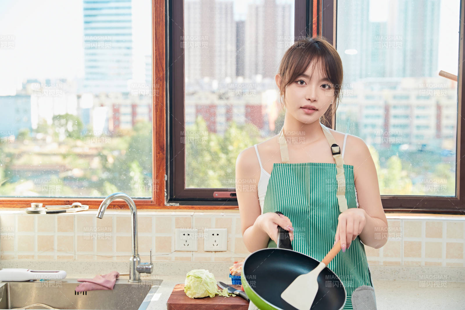 在厨房下厨做饭的年轻亚洲女性