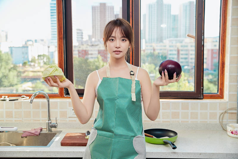 在厨房下厨做饭的年轻亚洲女性