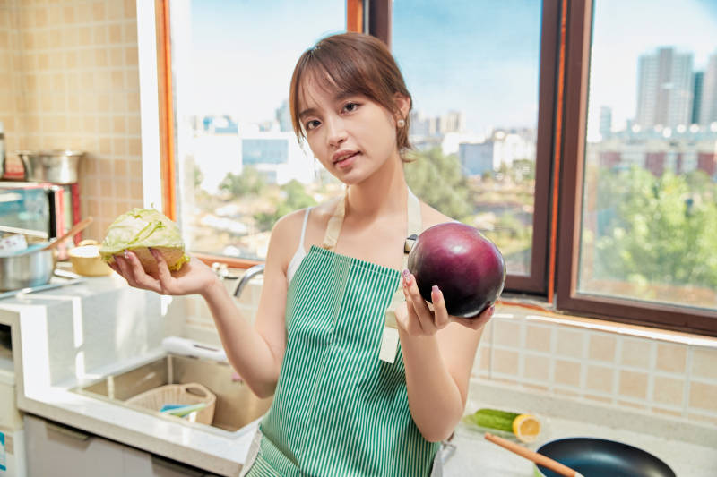 在厨房下厨做饭的年轻亚洲女性