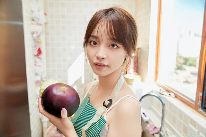 在厨房下厨做饭的年轻亚洲女性