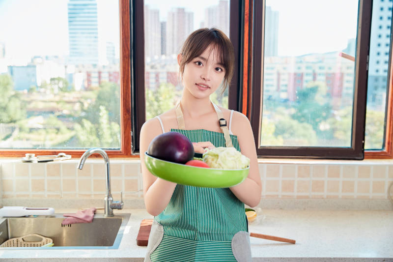 在厨房下厨做饭的年轻亚洲女性