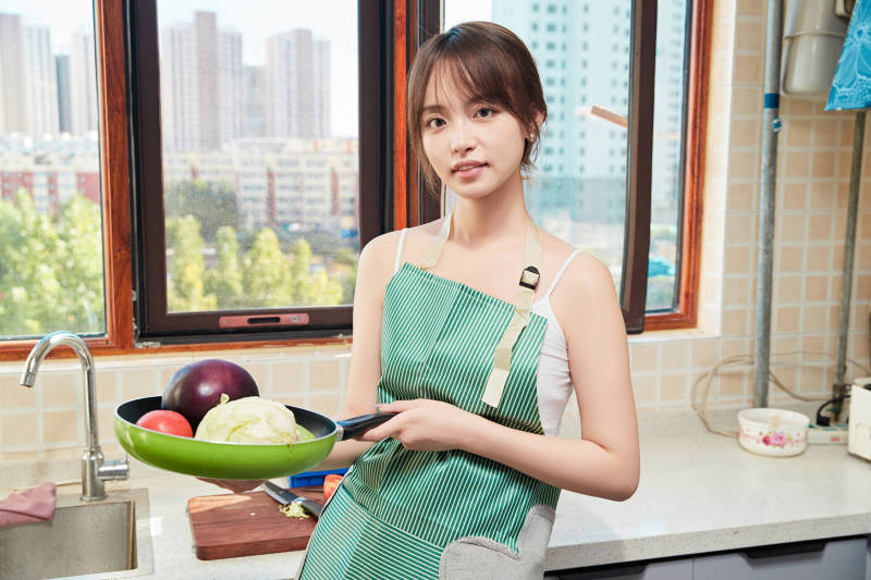 在厨房下厨做饭的年轻亚洲女性