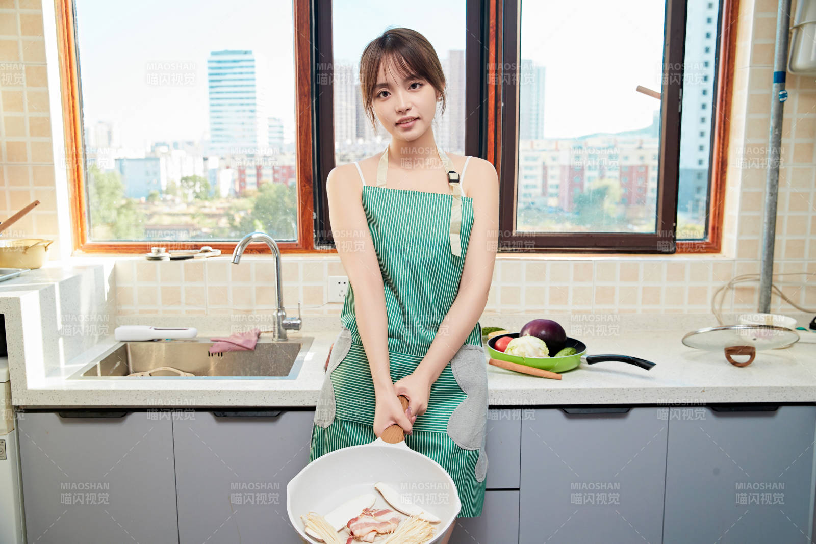 在廚房下廚做飯的年輕亞洲女性