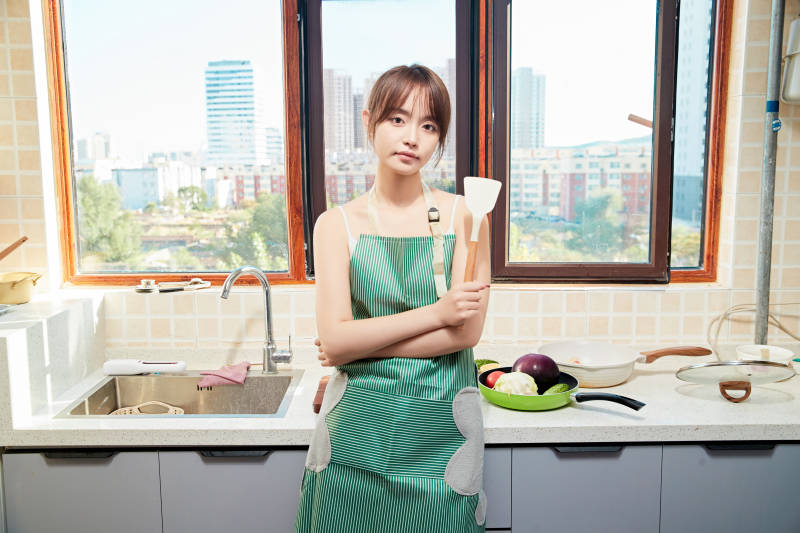 在厨房下厨做饭的年轻亚洲女性