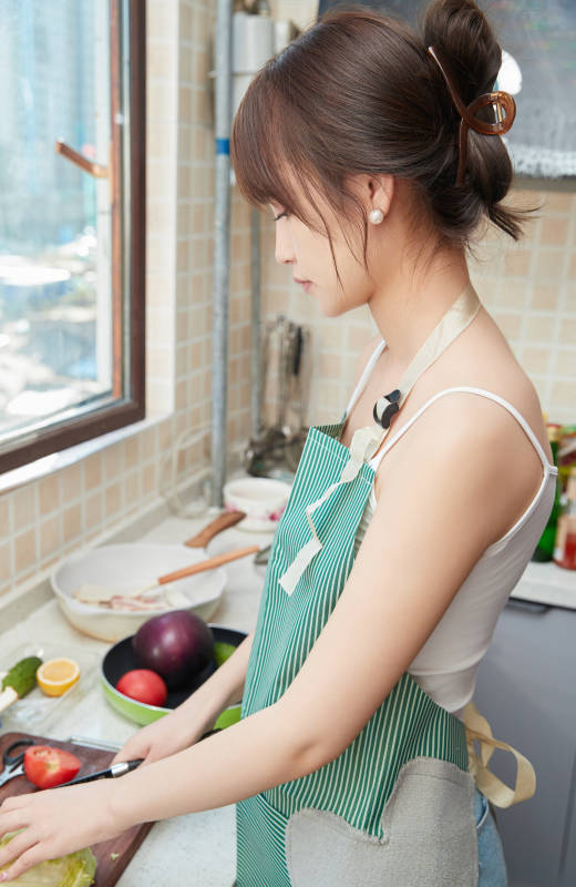 在厨房下厨做饭的年轻亚洲女性