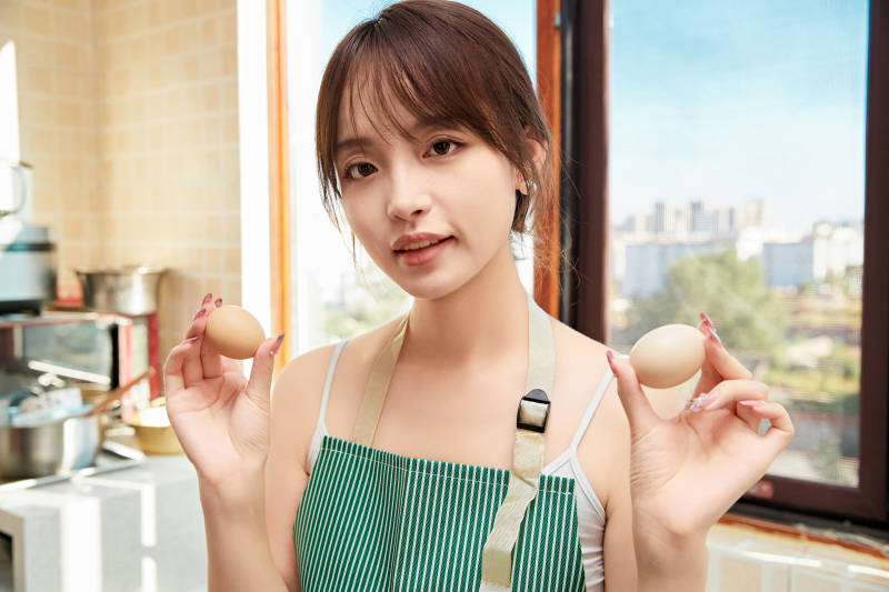 在厨房下厨做饭的年轻亚洲女性