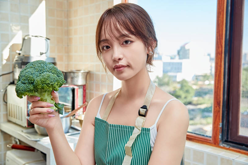 在厨房下厨做饭的年轻亚洲女性