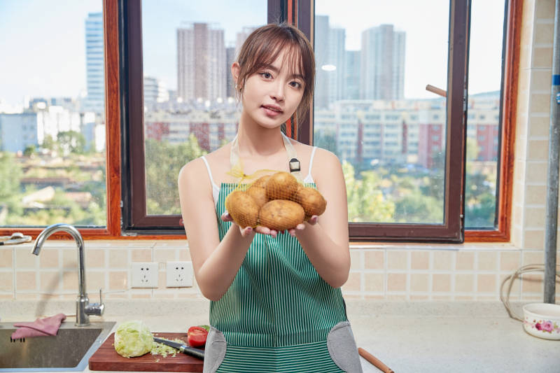 在厨房下厨做饭的年轻亚洲女性