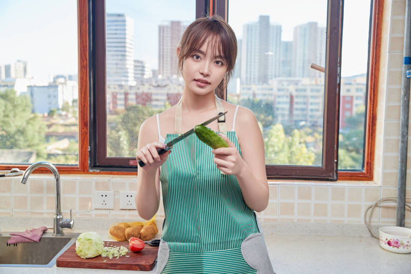 在厨房下厨做饭的年轻亚洲女性