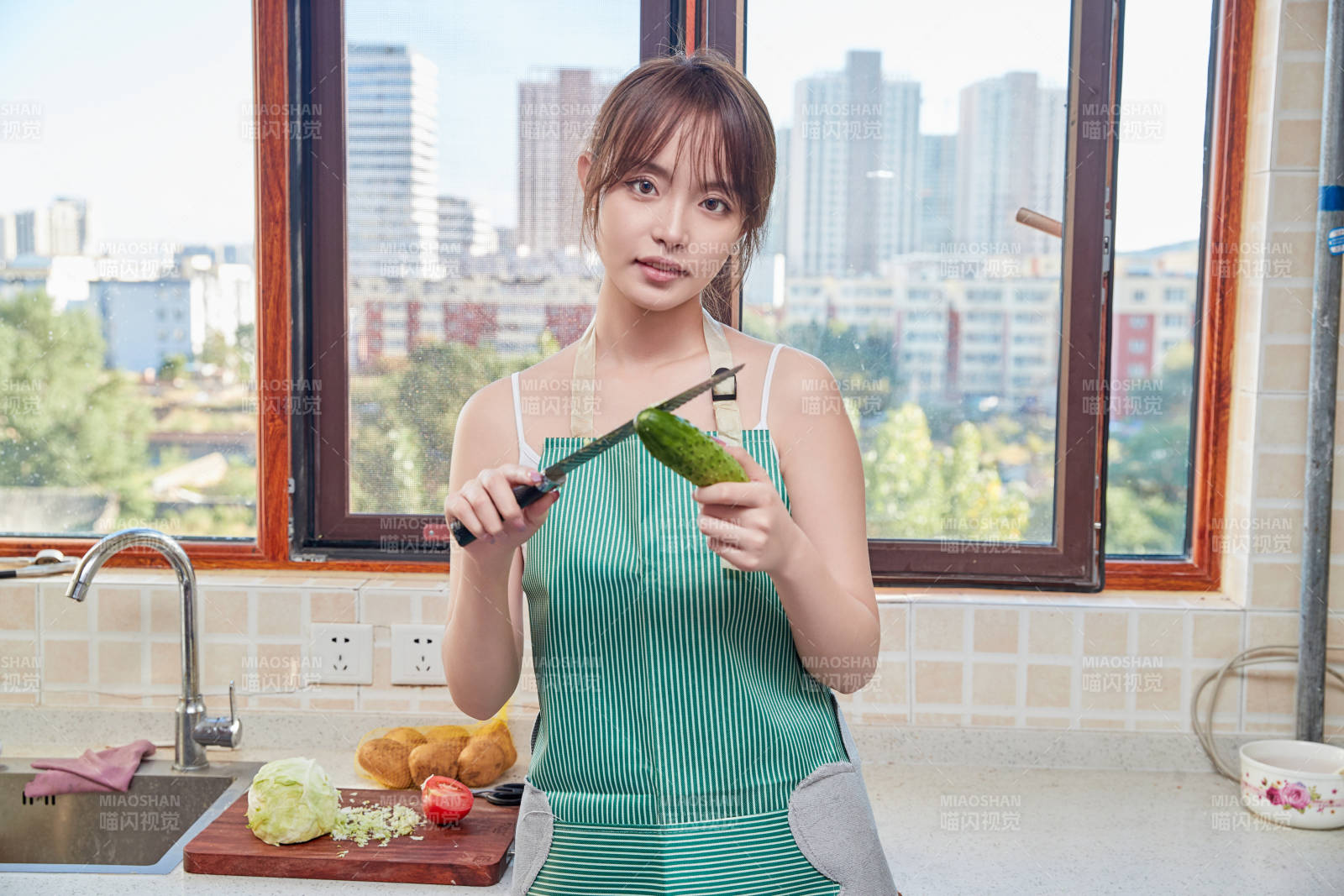 在廚房下廚做飯的年輕亞洲女性