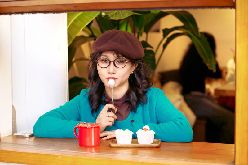 冬日午后坐在咖啡店吃蛋糕喝咖啡的亚洲美女