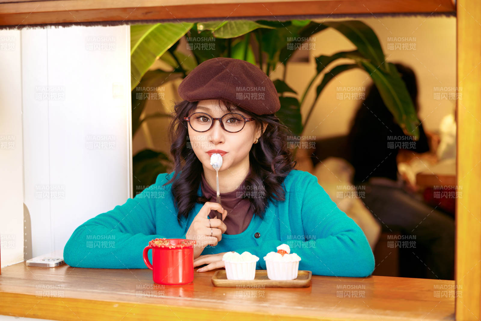 冬日午后坐在咖啡店吃蛋糕喝咖啡的亚洲美女