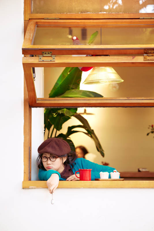 冬日午后坐在咖啡店吃蛋糕喝咖啡的亚洲美女