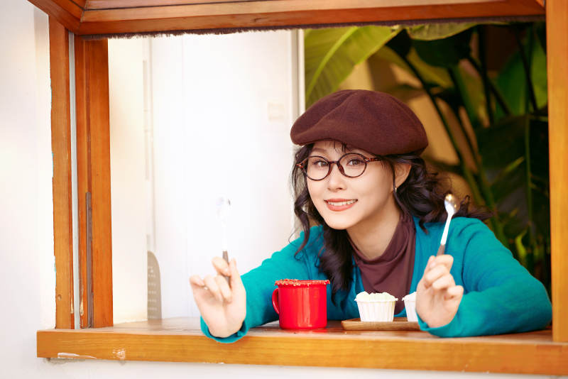 冬日午后坐在咖啡店吃蛋糕喝咖啡的亚洲美女