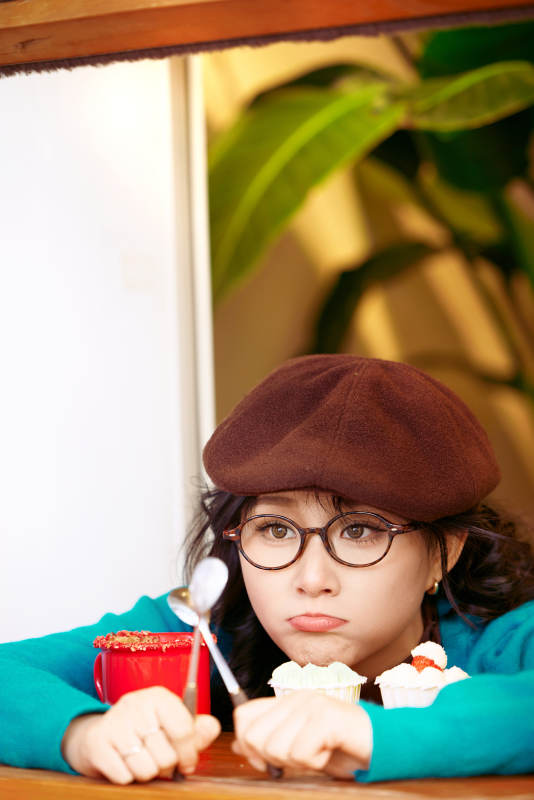 冬日午后坐在咖啡店吃蛋糕喝咖啡的亚洲美女