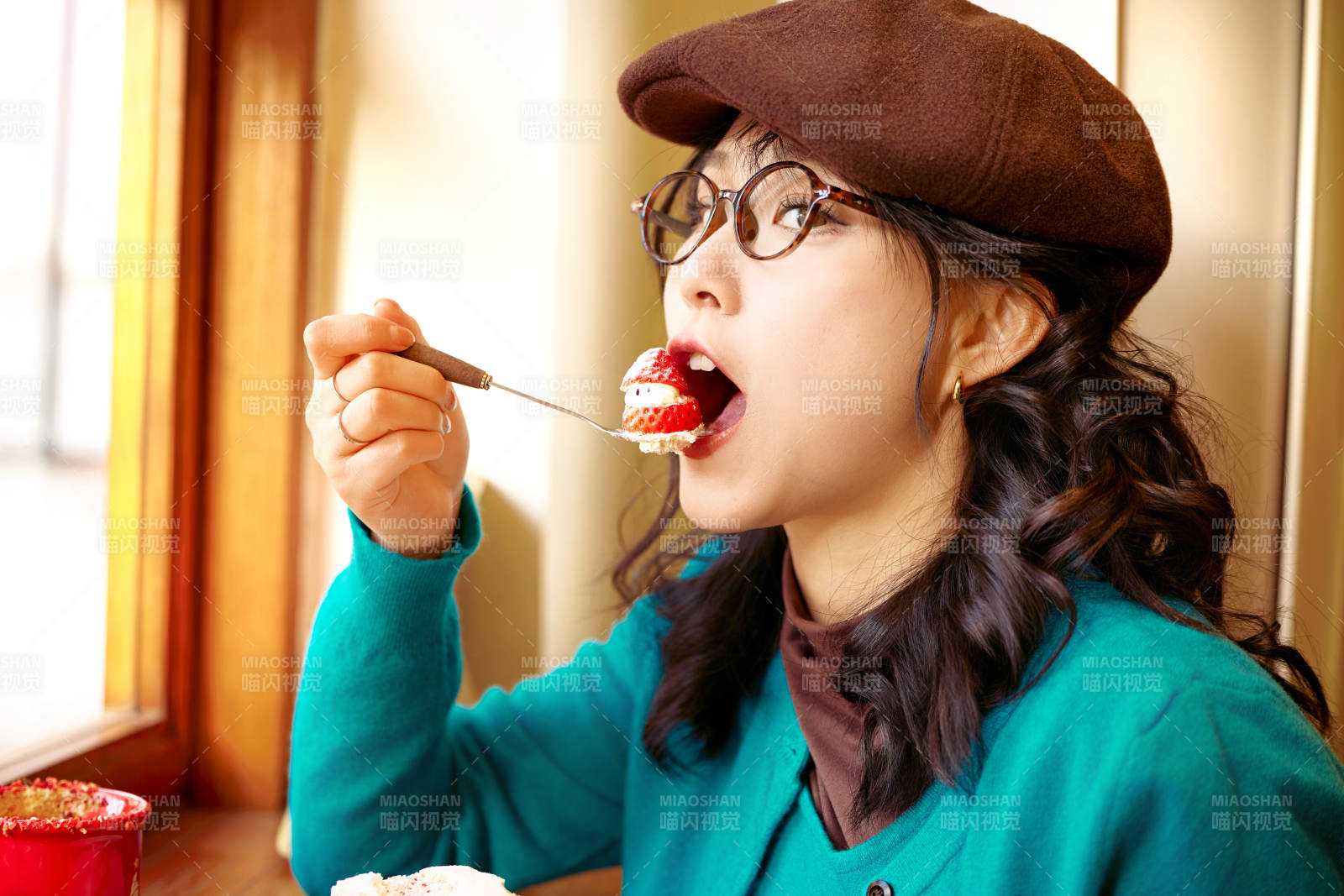 冬日午后坐在咖啡店吃蛋糕喝咖啡的亚洲美女