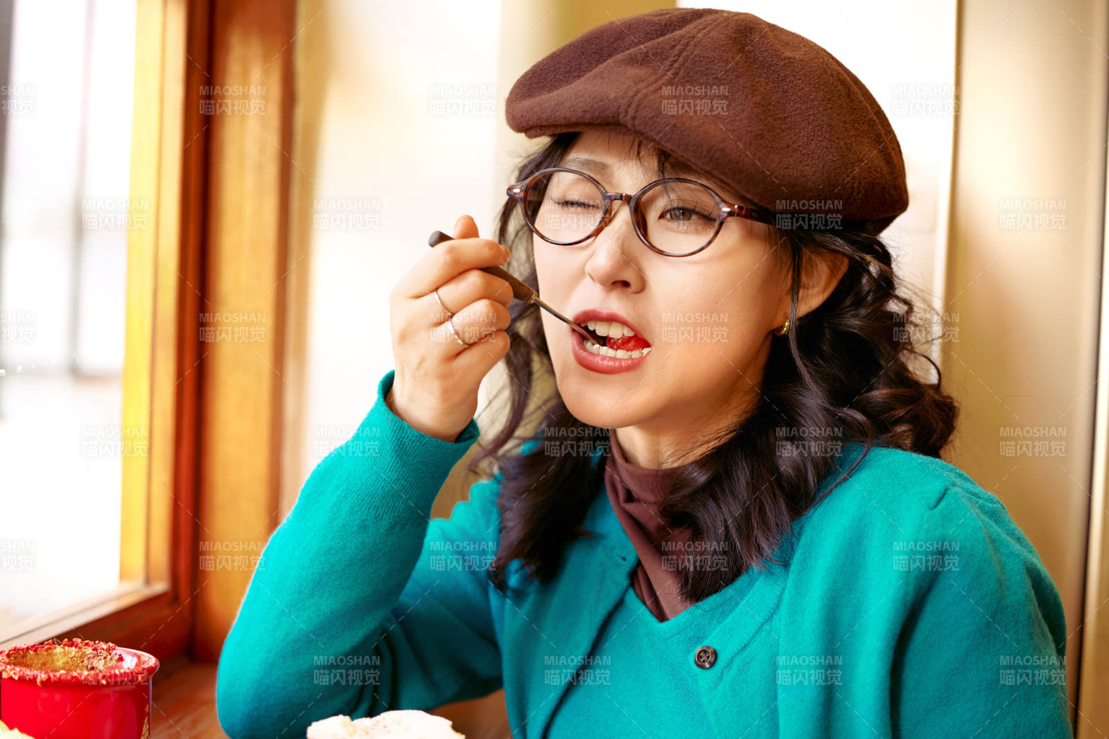 冬日午后坐在咖啡店吃蛋糕喝咖啡的亚洲美女