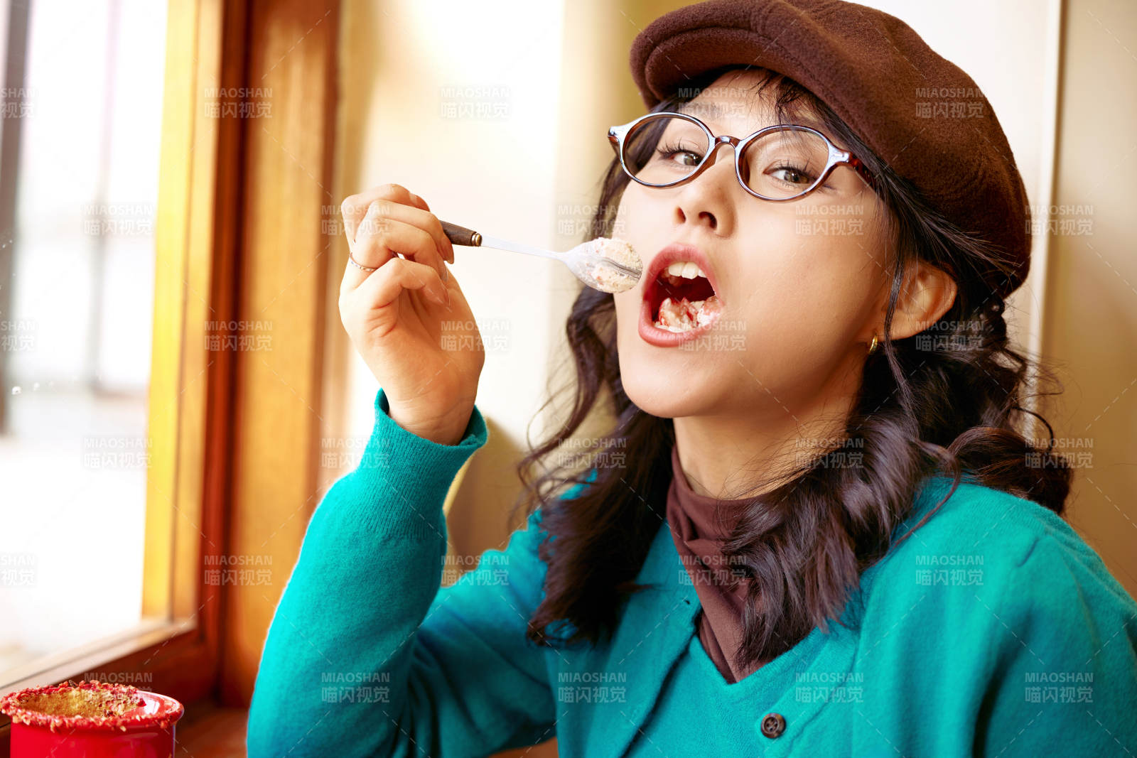 冬日午后坐在咖啡店吃蛋糕喝咖啡的亚洲美女