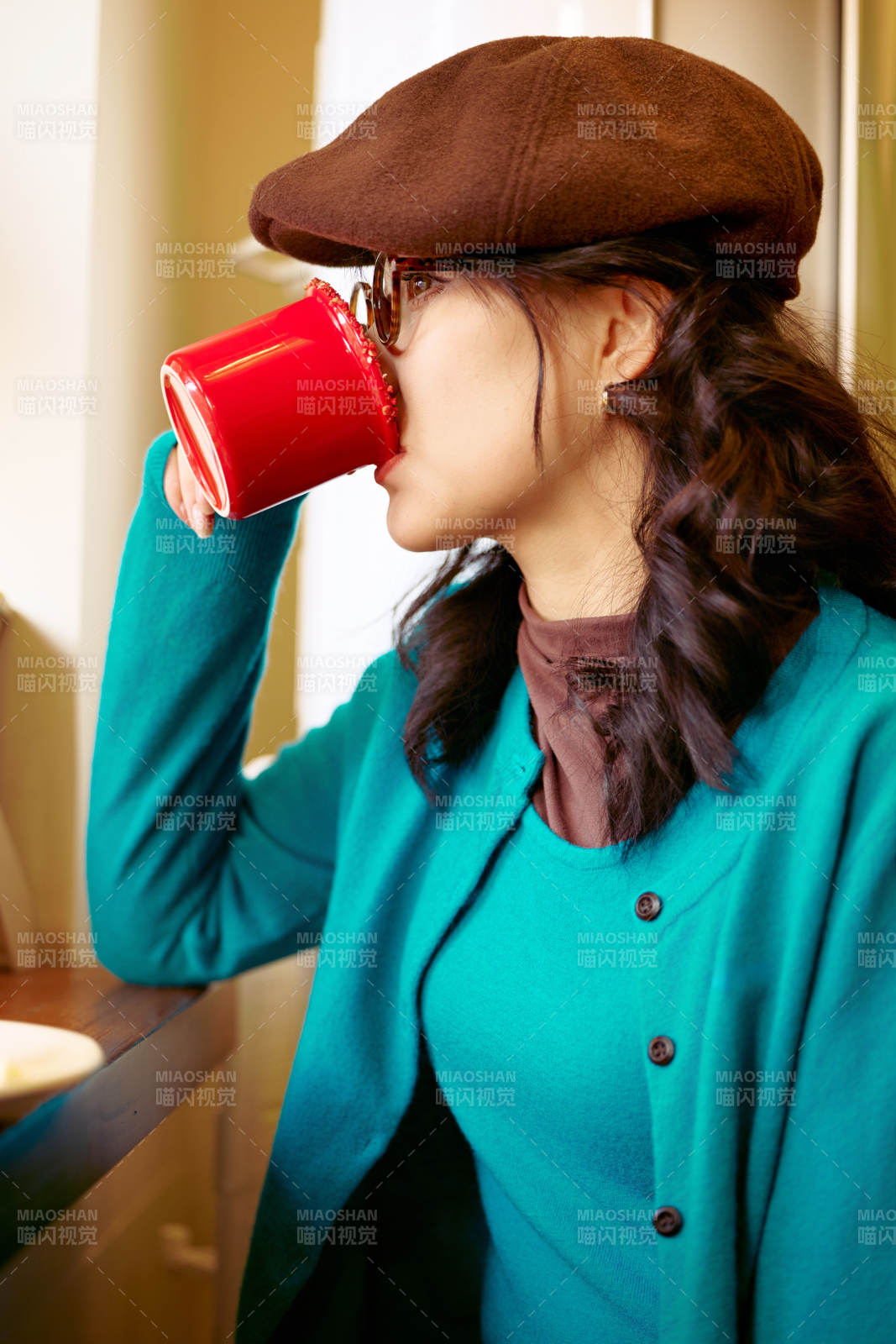 冬日午后坐在咖啡店吃蛋糕喝咖啡的亚洲美女