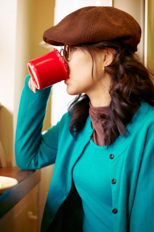 冬日午后坐在咖啡店吃蛋糕喝咖啡的亚洲美女