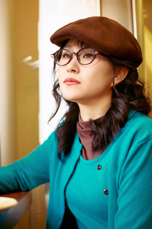 冬日午后坐在咖啡店吃蛋糕喝咖啡的亚洲美女