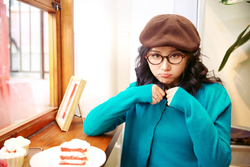 冬日午后坐在咖啡店吃蛋糕喝咖啡的亚洲美女