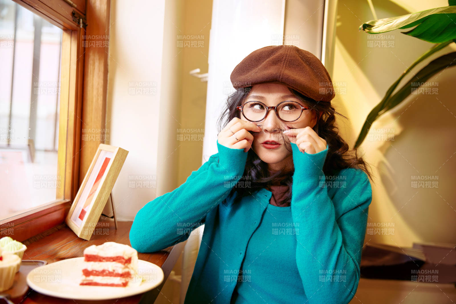 冬日午后坐在咖啡店吃蛋糕喝咖啡的亚洲美女