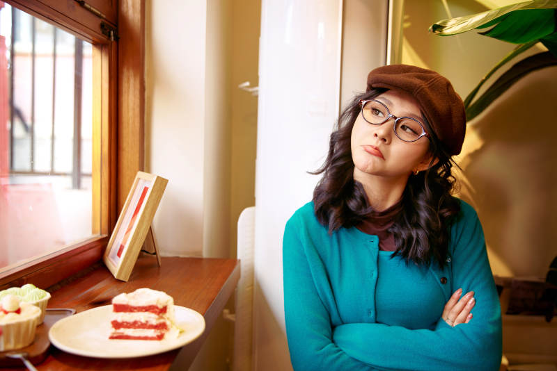 冬日午后坐在咖啡店吃蛋糕喝咖啡的亚洲美女