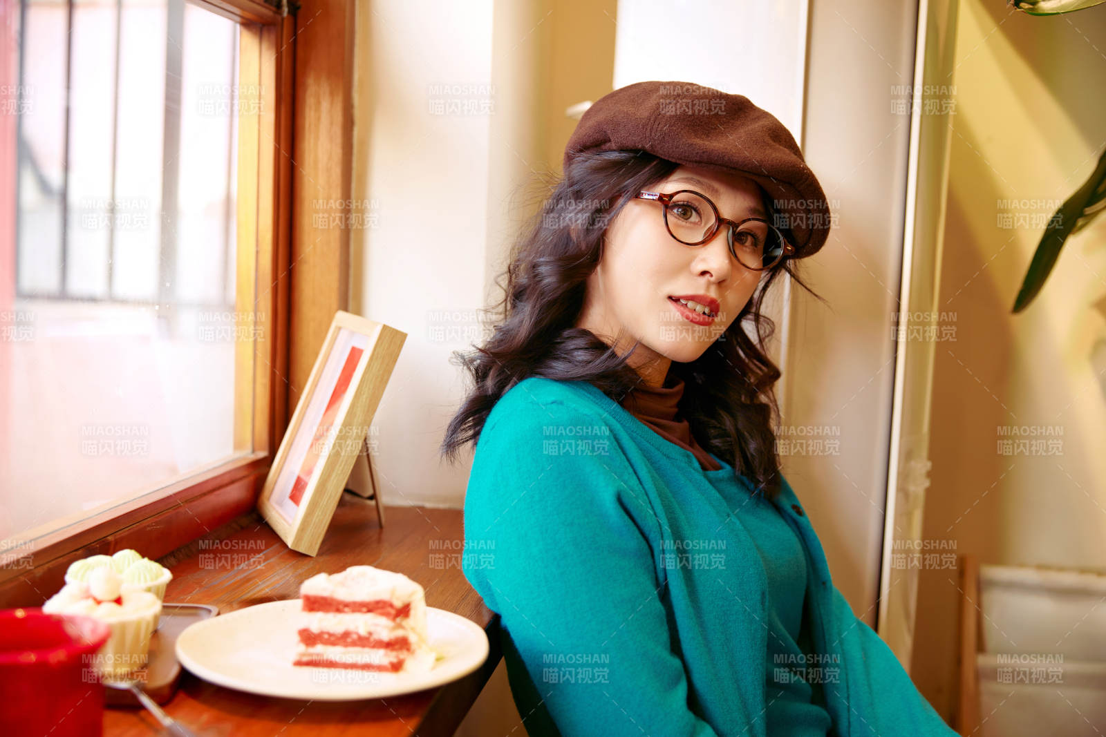 冬日午后坐在咖啡店吃蛋糕喝咖啡的亚洲美女