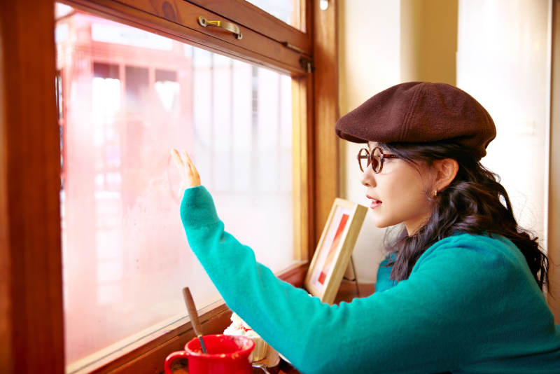 冬日午后坐在咖啡店吃蛋糕喝咖啡的亚洲美女