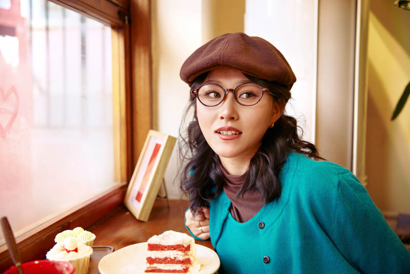 冬日午后坐在咖啡店吃蛋糕喝咖啡的亚洲美女