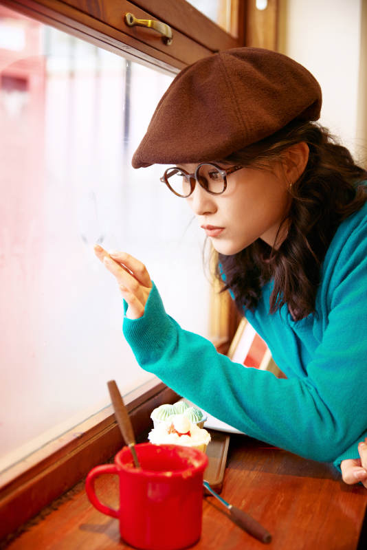 冬日午后坐在咖啡店吃蛋糕喝咖啡的亚洲美女