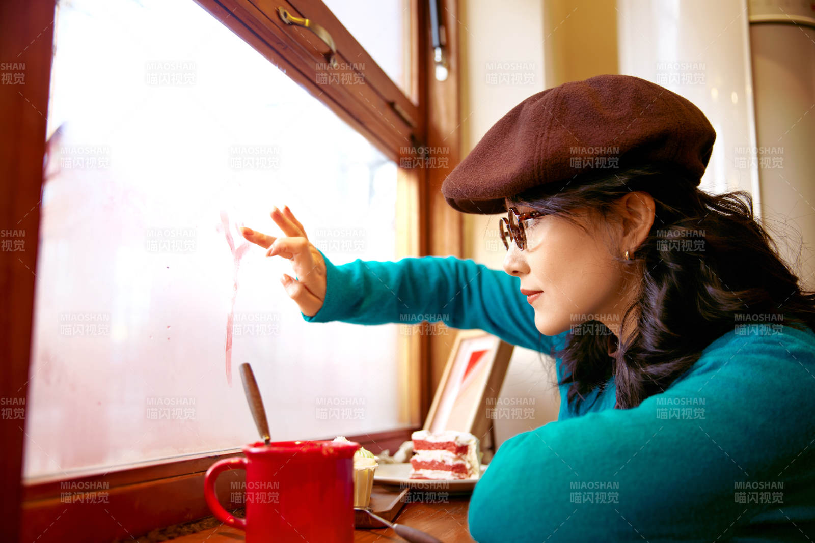 冬日午后坐在咖啡店吃蛋糕喝咖啡的亚洲美女
