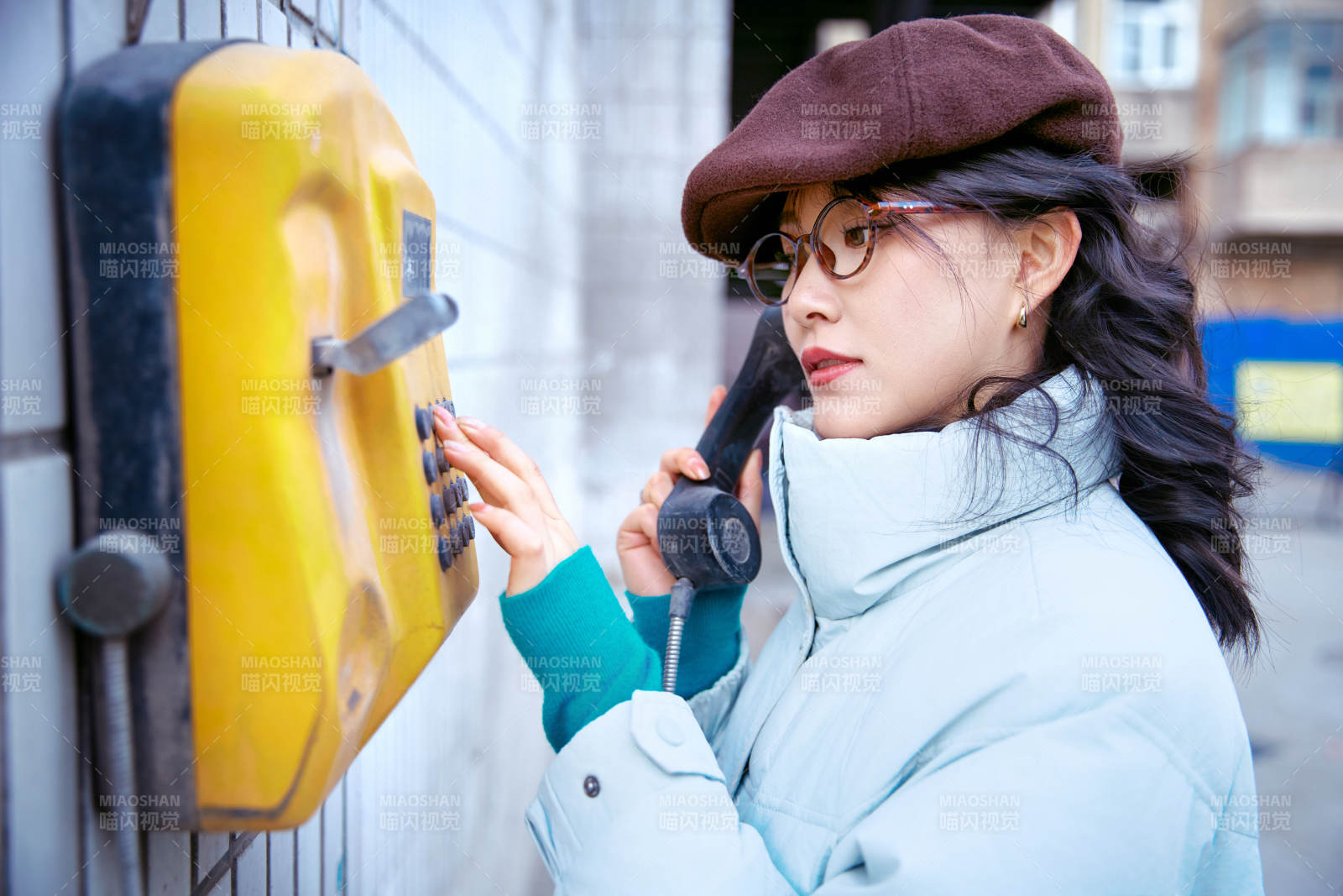 在老旧社区院落回拨打IC卡电话的美女