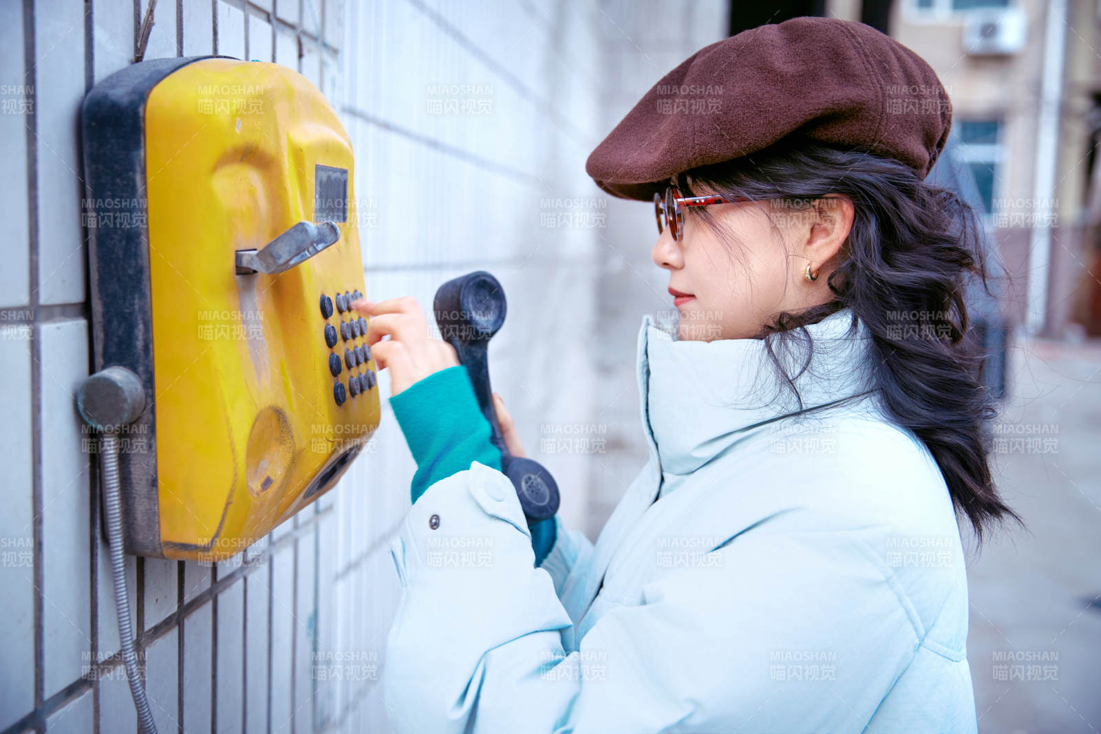 在老旧社区院落回拨打IC卡电话的美女