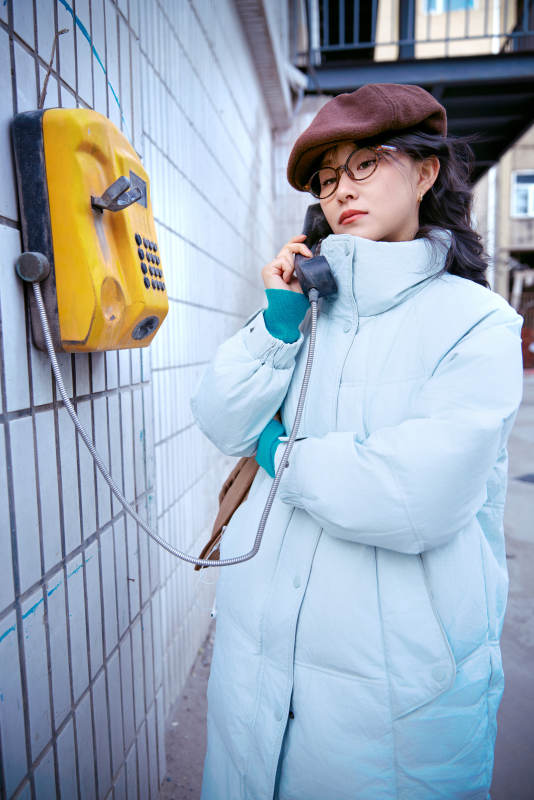 在老旧社区院落回拨打IC卡电话的美女