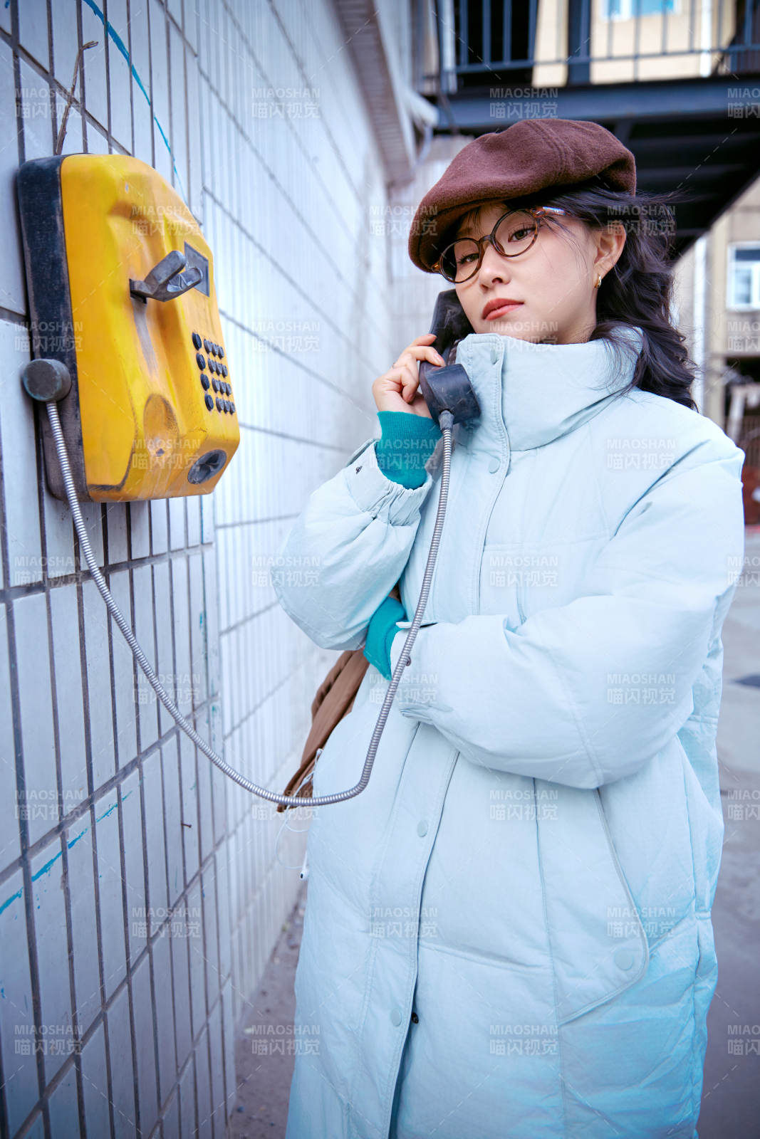 在老旧社区院落回拨打IC卡电话的美女