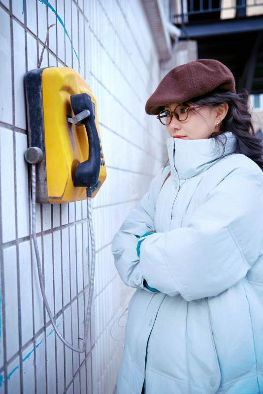 在老旧社区院落回拨打IC卡电话的美女