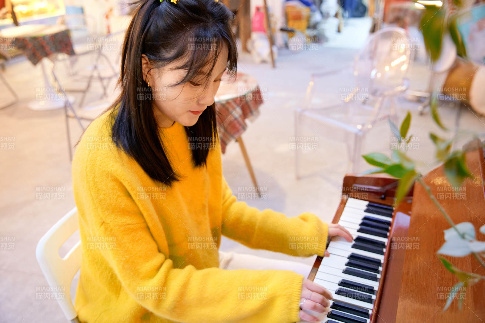 在咖啡店演奏钢琴的东方美女