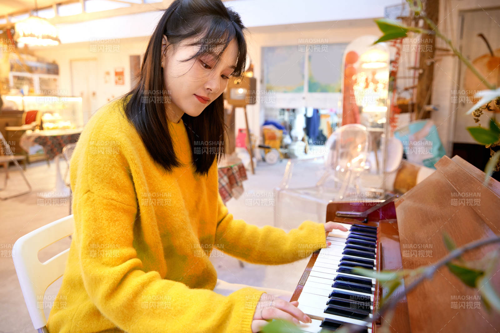 在咖啡店演奏钢琴的东方美女